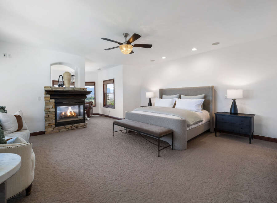 This luxurious bedroom boasts a cozy fireplace, creating a warm and inviting atmosphere.