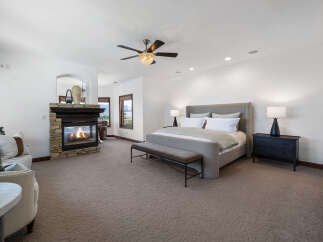 This luxurious bedroom boasts a cozy fireplace, creating a warm and inviting atmosphere.