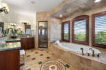 This luxurious master bathroom boasts a spacious layout with dual vanities, a large soaking tub, and a separate shower.