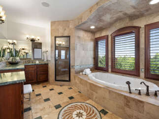 This luxurious master bathroom boasts a spacious layout with dual vanities, a large soaking tub, and a separate shower.