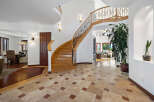 This stunning home boasts a grand entrance with a sweeping curved staircase, showcasing exquisite craftsmanship.