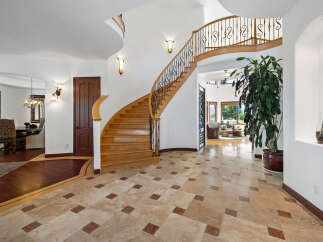 This stunning home boasts a grand entrance with a sweeping curved staircase, showcasing exquisite craftsmanship.