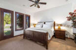 This luxurious bedroom boasts a king-size bed with a wooden frame, complemented by plush bedding and nightstands with lamps.