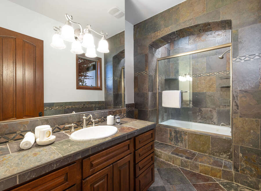 This luxurious bathroom boasts a stunning slate tile design, creating a spa-like atmosphere.