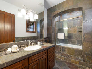 This luxurious bathroom boasts a stunning slate tile design, creating a spa-like atmosphere.