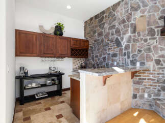 This stunning home boasts a built-in bar with granite countertops and custom cabinetry, perfect for entertaining guests.
