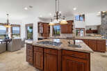 This stunning kitchen boasts a large island with granite countertops, a gas cooktop, and ample cabinetry.