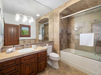 This luxurious bathroom boasts a spacious shower with glass enclosure and a modern vanity with ample storage.