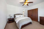 This bedroom boasts a cozy and elegant atmosphere, featuring a plush bed with a light grey duvet and crisp white sheets.