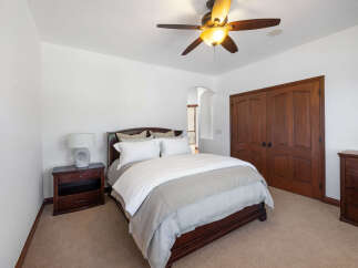 This bedroom boasts a cozy and elegant atmosphere, featuring a plush bed with a light grey duvet and crisp white sheets.