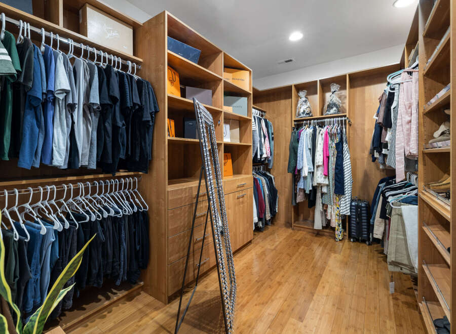 This luxurious walk-in closet boasts ample storage space with custom built-in shelves and hanging rods.