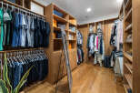 This luxurious walk-in closet boasts ample storage space with custom built-in shelves and hanging rods.