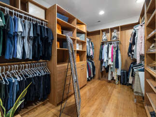 This luxurious walk-in closet boasts ample storage space with custom built-in shelves and hanging rods.