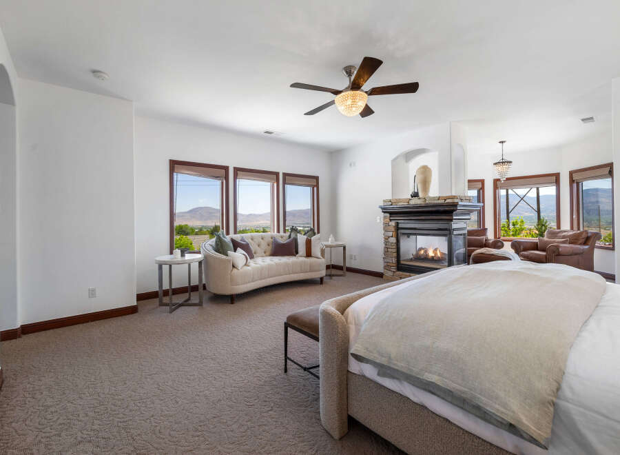 Luxurious master bedroom with stunning mountain views and a cozy fireplace.
