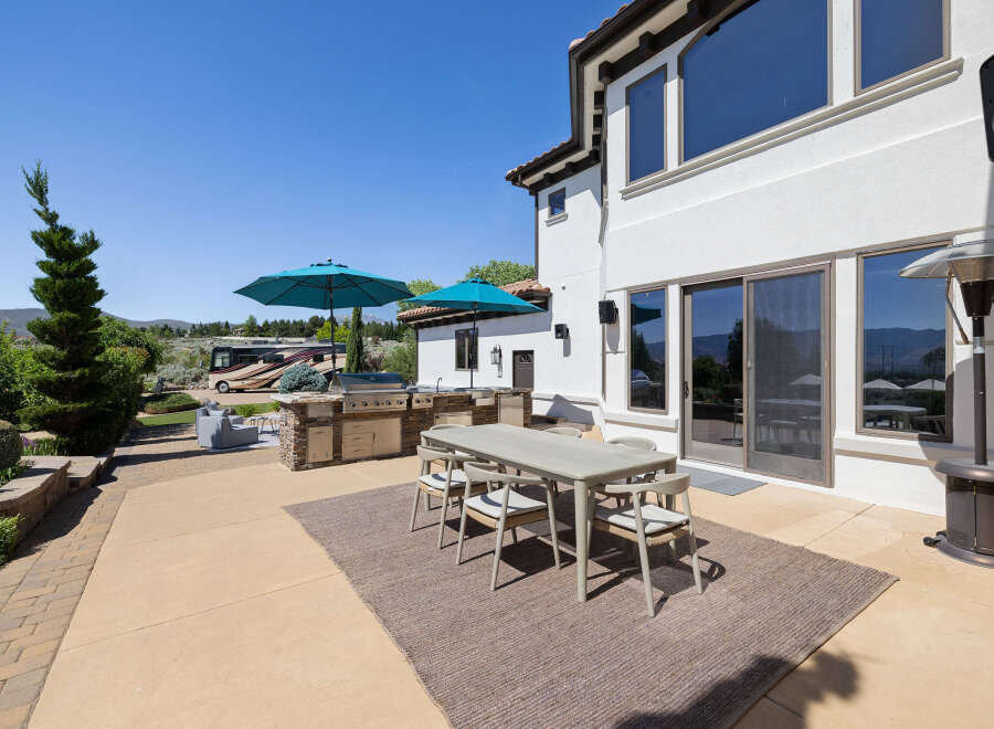This stunning property boasts a spacious outdoor patio perfect for entertaining, complete with a built-in BBQ, comfortable seating area, and stylish dining set.