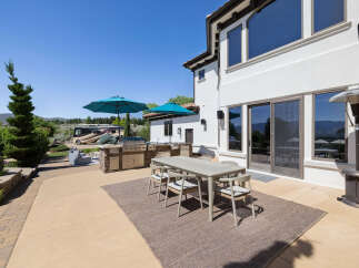 This stunning property boasts a spacious outdoor patio perfect for entertaining, complete with a built-in BBQ, comfortable seating area, and stylish dining set.