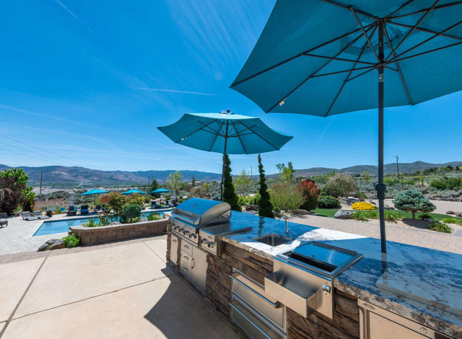 Luxury outdoor kitchen with granite countertops and stainless steel appliances, perfect for entertaining.