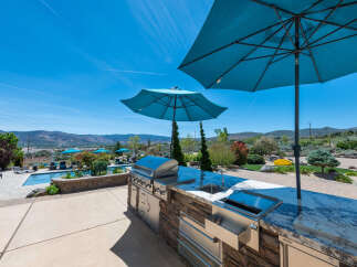 Luxury outdoor kitchen with granite countertops and stainless steel appliances, perfect for entertaining.