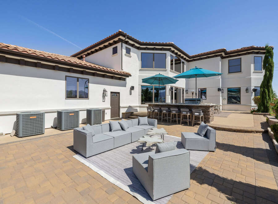 This stunning property boasts a spacious outdoor patio perfect for entertaining, complete with a built-in bar and comfortable seating areas.