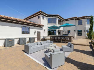 This stunning property boasts a spacious outdoor patio perfect for entertaining, complete with a built-in bar and comfortable seating areas.