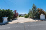 This stunning property boasts a long driveway leading to a luxurious, two-story home.