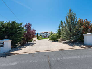 This stunning property boasts a long driveway leading to a luxurious, two-story home.