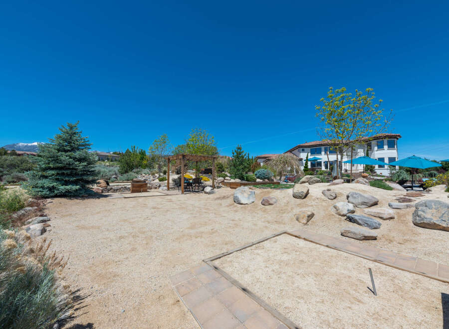 This stunning property boasts a spacious backyard perfect for outdoor entertainment, featuring a sand volleyball court and horseshoe pit.
