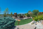 This stunning property boasts a beautifully landscaped backyard, complete with a stone fireplace and seating area, perfect for outdoor entertaining.
