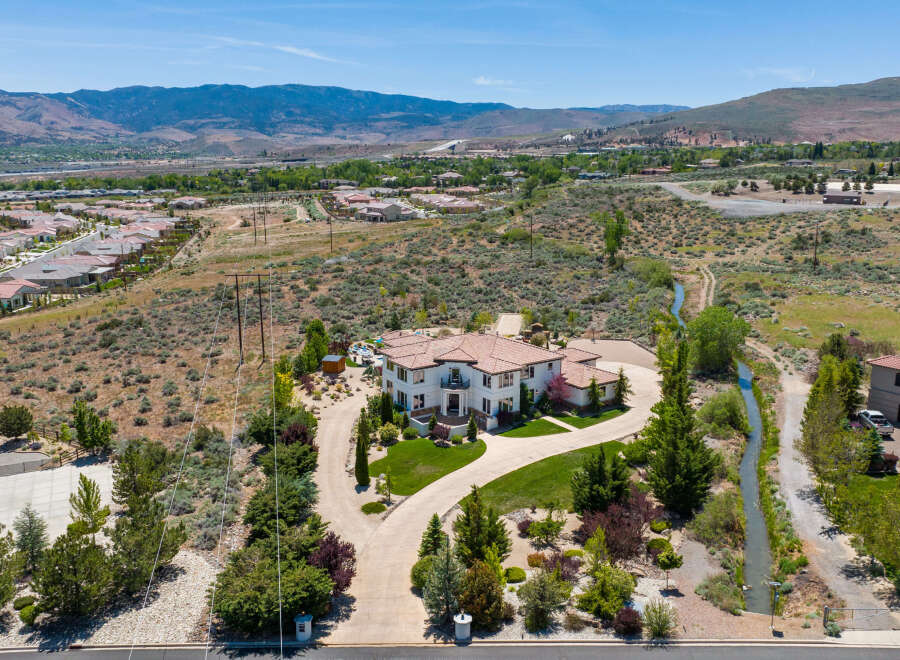 This stunning property boasts a large, luxurious home with a beautiful landscape and a private driveway.