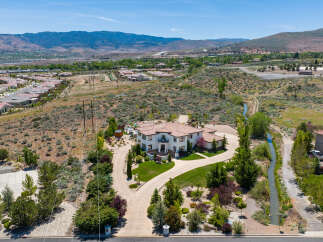 This stunning property boasts a large, luxurious home with a beautiful landscape and a private driveway.
