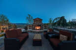 This stunning outdoor patio features a beautiful stone fireplace, perfect for enjoying cool evenings.