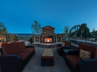 This stunning outdoor patio features a beautiful stone fireplace, perfect for enjoying cool evenings.