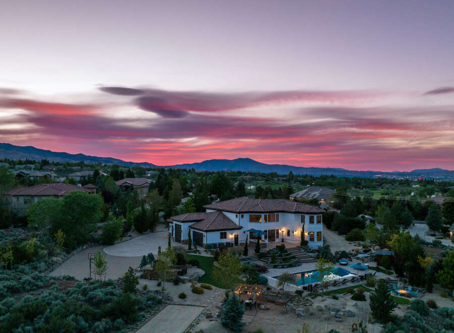 Luxury estate boasting a stunning sunset view, expansive backyard oasis with a pool and fire pit, and a spacious interior perfect for entertaining.