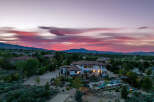 Luxury estate boasting a stunning sunset view, expansive backyard oasis with a pool and fire pit, and a spacious interior perfect for entertaining.