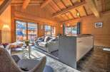 This stunning chalet boasts a spacious open-plan living area with floor-to-ceiling windows offering breathtaking mountain views.