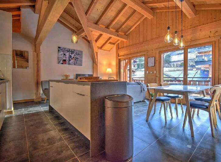 This stunning chalet boasts a spacious open-plan living area with a modern kitchen and dining area.