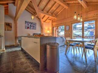 This stunning chalet boasts a spacious open-plan living area with a modern kitchen and dining area.