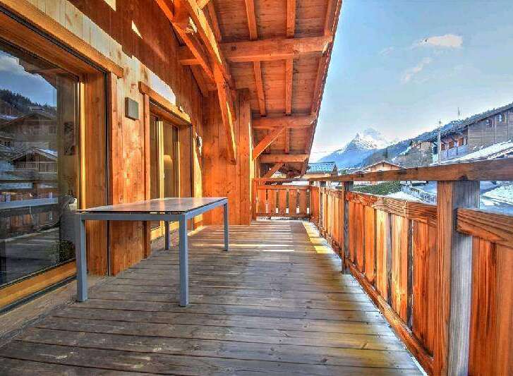 This stunning chalet boasts a spacious balcony with breathtaking mountain views.