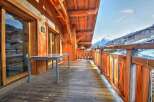 This stunning chalet boasts a spacious balcony with breathtaking mountain views.