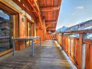 This stunning chalet boasts a spacious balcony with breathtaking mountain views.