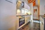 Modern kitchen with sleek white cabinets and stainless steel appliances.
