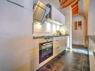 Modern kitchen with sleek white cabinets and stainless steel appliances.