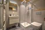 Modern bathroom with a walk-in shower, sleek vanity, and a wall-mounted toilet.