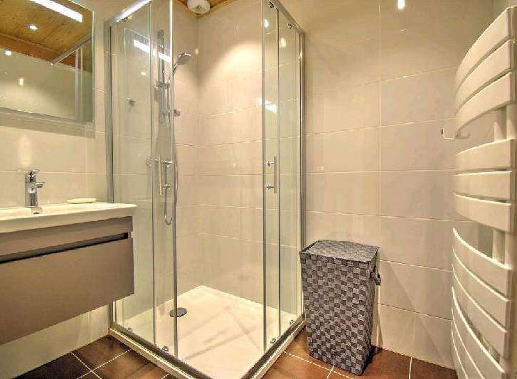 Modern bathroom with a walk-in shower, stylish vanity, and heated towel rack.