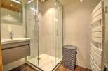 Modern bathroom with a walk-in shower, stylish vanity, and heated towel rack.