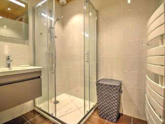 Modern bathroom with a walk-in shower, stylish vanity, and heated towel rack.