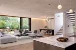 Stunning modern home boasts an open floor plan with floor-to-ceiling windows showcasing a lush garden view.