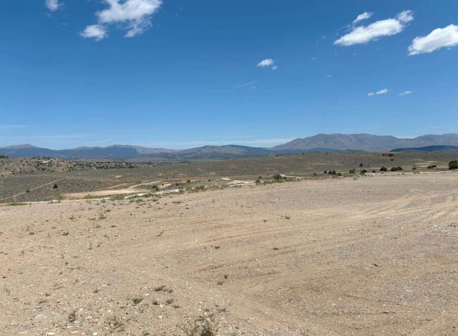 This expansive property boasts breathtaking views of the surrounding mountains and a vast, open landscape perfect for outdoor enthusiasts.