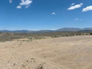 This expansive property boasts breathtaking views of the surrounding mountains and a vast, open landscape perfect for outdoor enthusiasts.