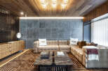 Luxury living room with Fendi decor, featuring a large sectional sofa, marble coffee tables, and a wood-paneled ceiling.